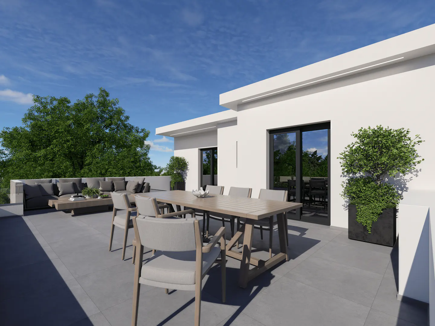 Modern rooftop patio with a gray sofa, wooden table, and chairs. A potted tree stands near a black-framed glass door.