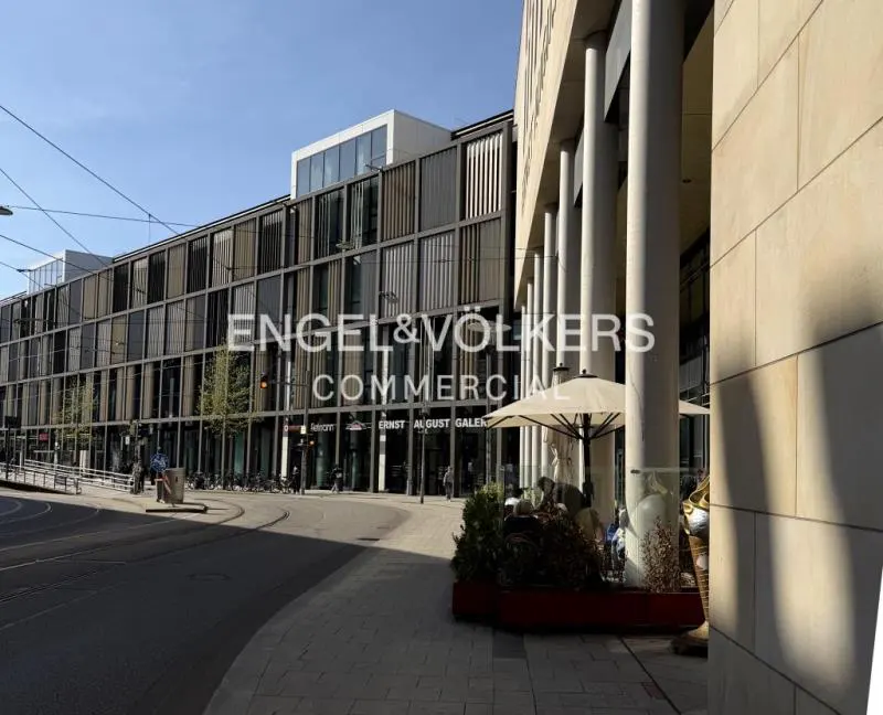 Exterior view of Ernst August Galerie, a modern commercial building with a cafe on the sidewalk.