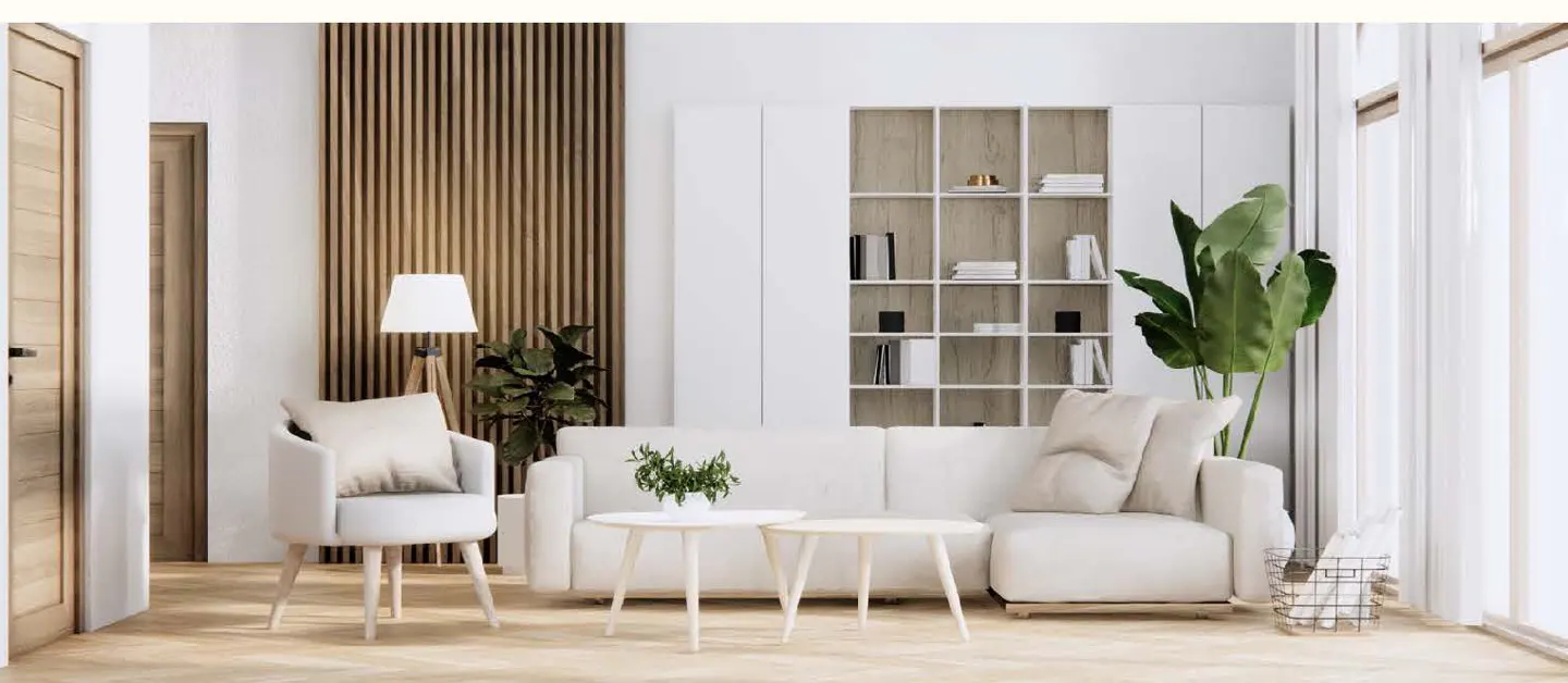 Bright living room with white sofa, chair, and built-in shelves. A wood slat wall and large windows add texture and light.
