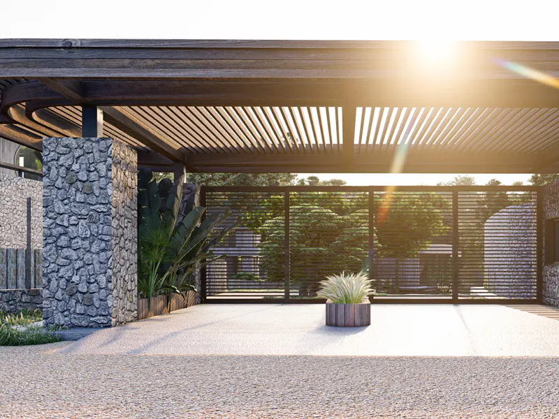 Exterior view of a modern home's entrance with a stone pillar, wooden pergola, and a black metal gate. A potted plant sits in the foreground.