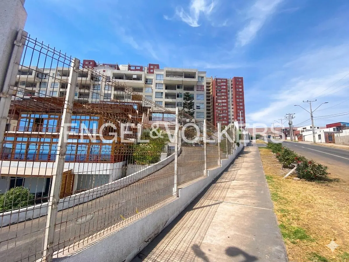 Exterior view of a multi-story building complex with a sidewalk and street. The Engel & Volkers logo is visible.