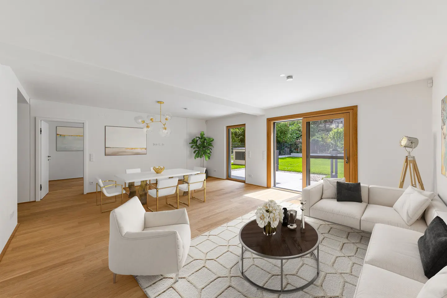 Bright, modern living room with white furniture, wood floors, and a dining area. Sliding glass doors open to a green lawn.