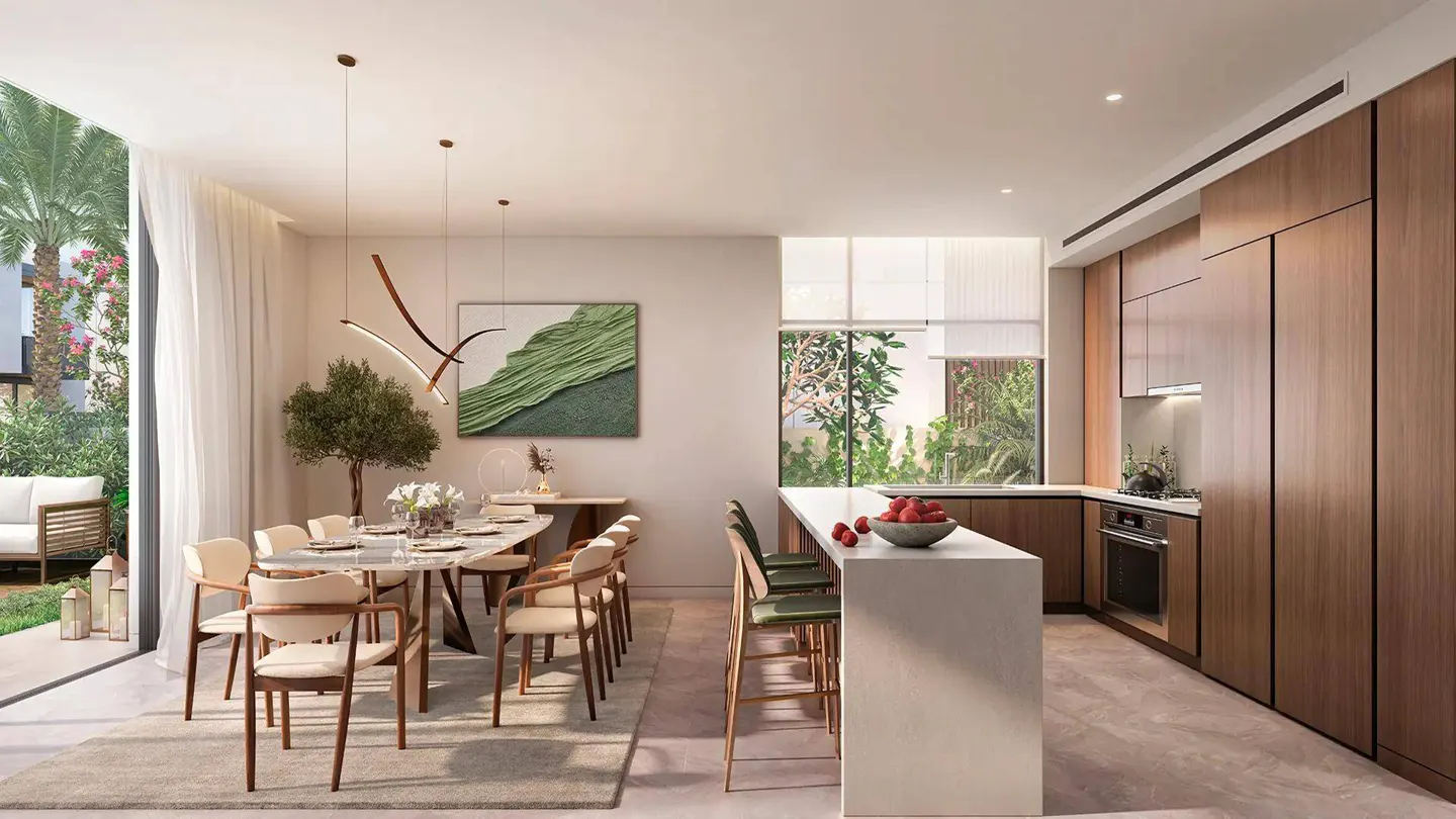 Open-concept kitchen and dining area with a marble table, wood cabinets, and a white island. Outside, a patio with a white sofa is visible.