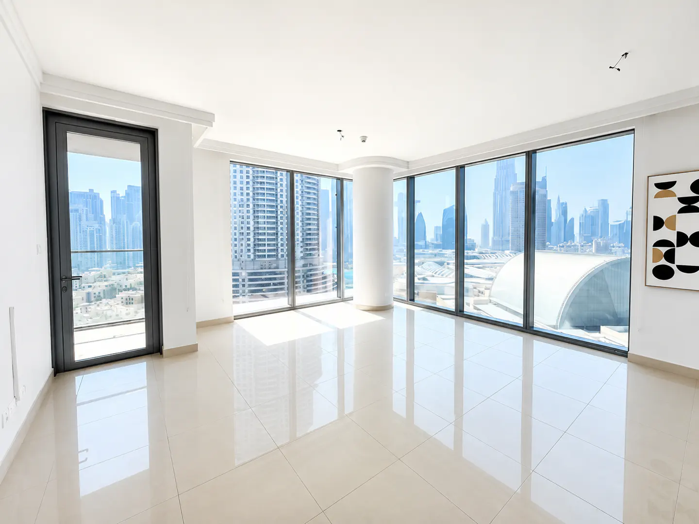 Empty modern apartment with white tile floors, floor-to-ceiling windows, and a panoramic view of the Dubai city skyline.