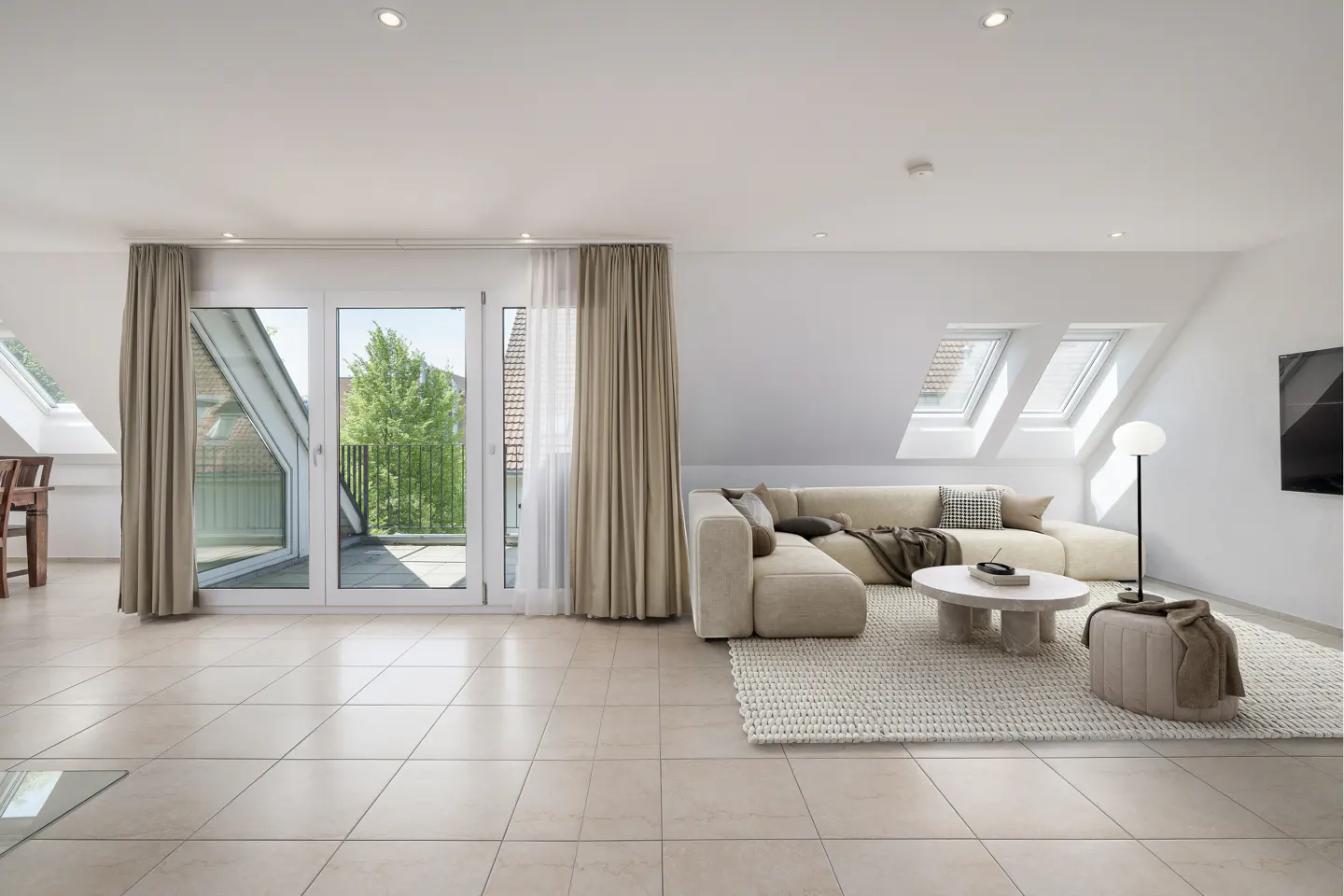 Bright living room with beige tile floor, sofa, and balcony. White walls and ceiling with skylights. Neutral tones create a modern, airy space.