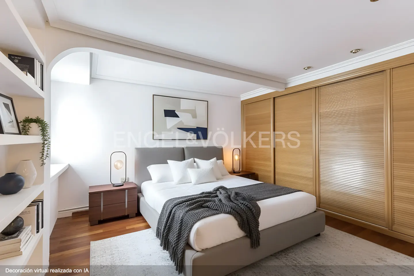 Bedroom with a gray bed, white linens, and a gray throw blanket. There are wooden nightstands with lamps, a built-in bookshelf, and a wooden closet.