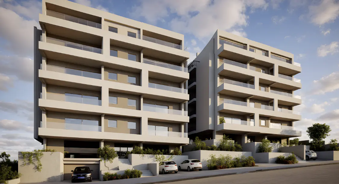 Modern multi-story apartment buildings with white balconies and beige walls, featuring parked cars and landscaping.