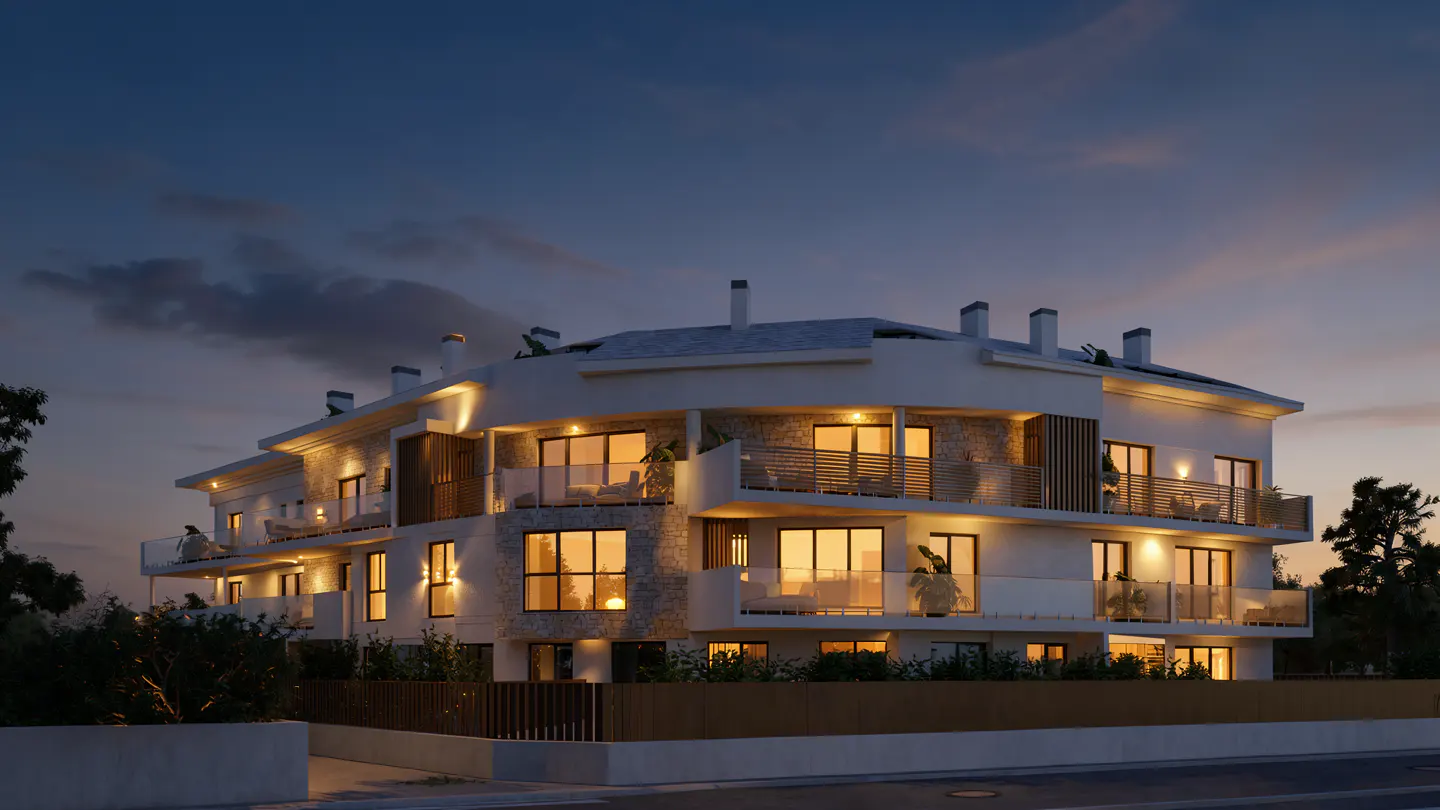 Three-story white apartment building with balconies at dusk. Lights are on inside.