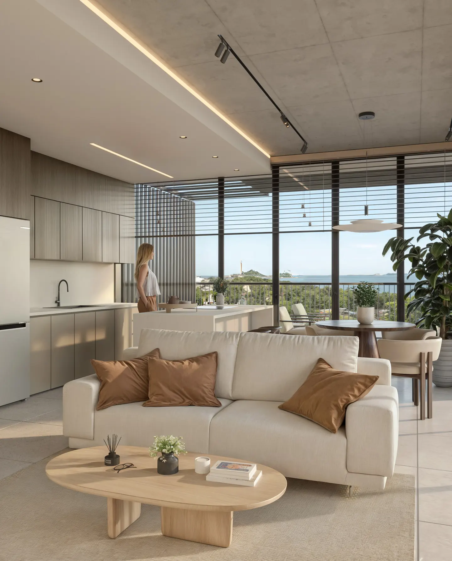 Bright, modern apartment interior with a white sofa, wood table, and a woman looking out the window at the ocean view.
