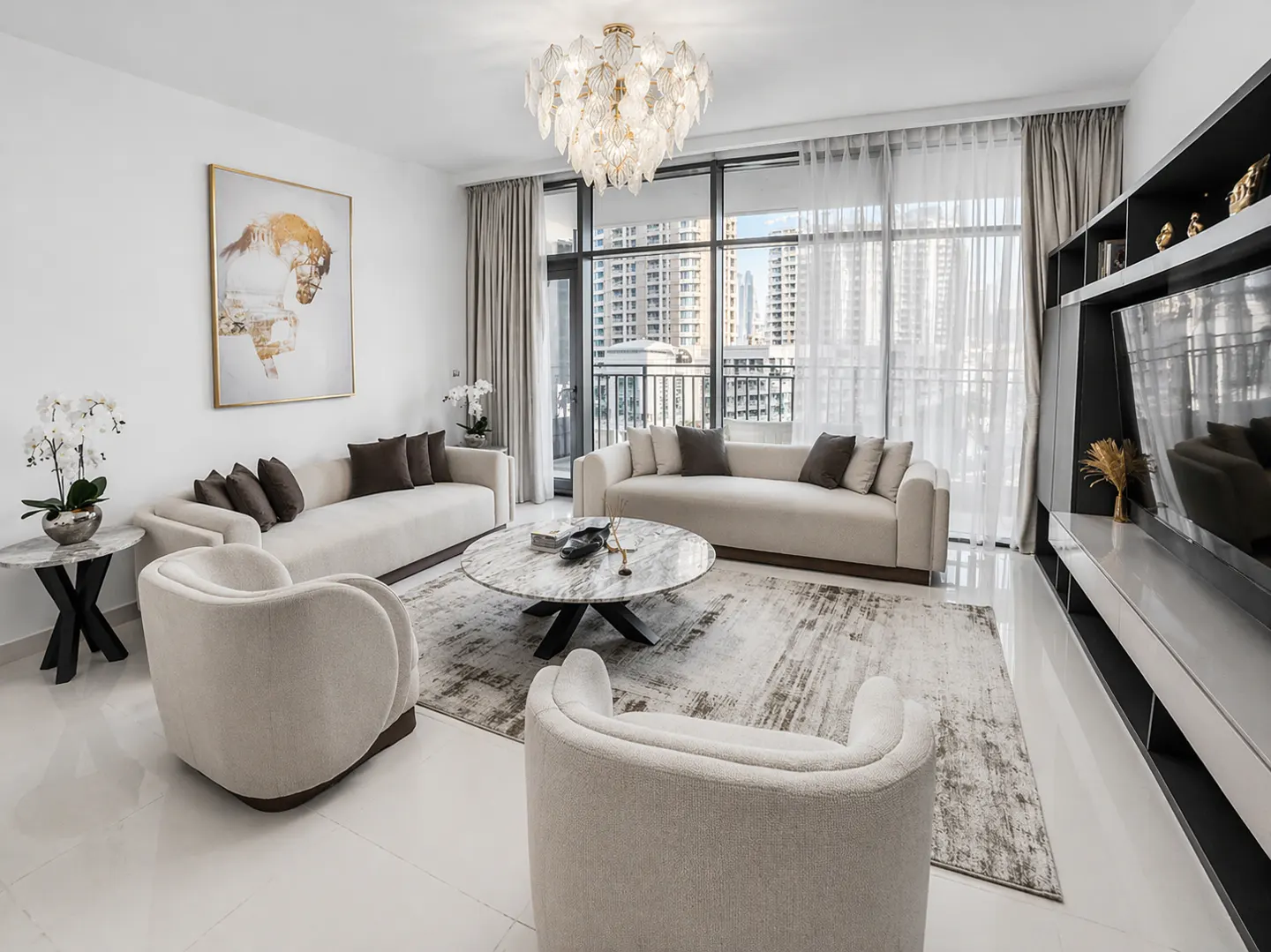 Bright living room with two sofas, two armchairs, and a marble coffee table on a patterned rug. A large window shows a city view.