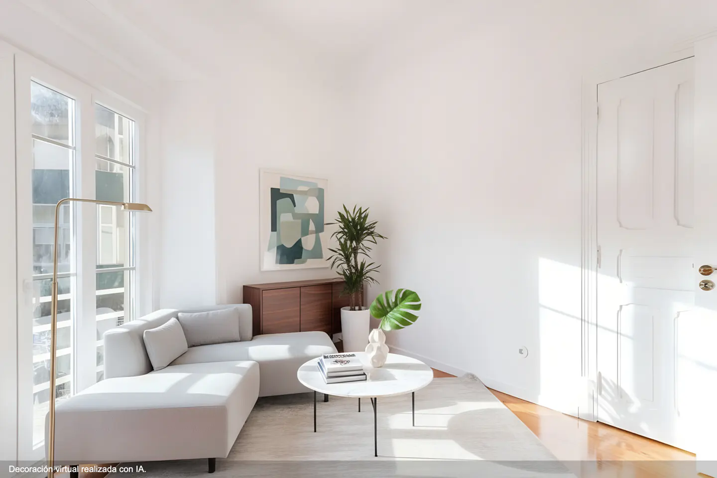 Bright living room with a gray sectional sofa, round coffee table, and a gold floor lamp by a window. A wood cabinet and abstract art are on the wall.