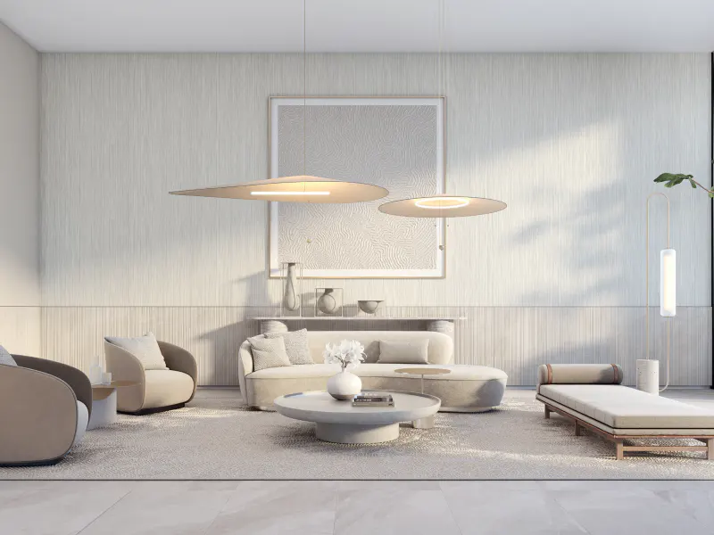 Bright, modern living room with beige furniture, including a sofa, chairs, and daybed. Two pendant lights hang above a round coffee table.