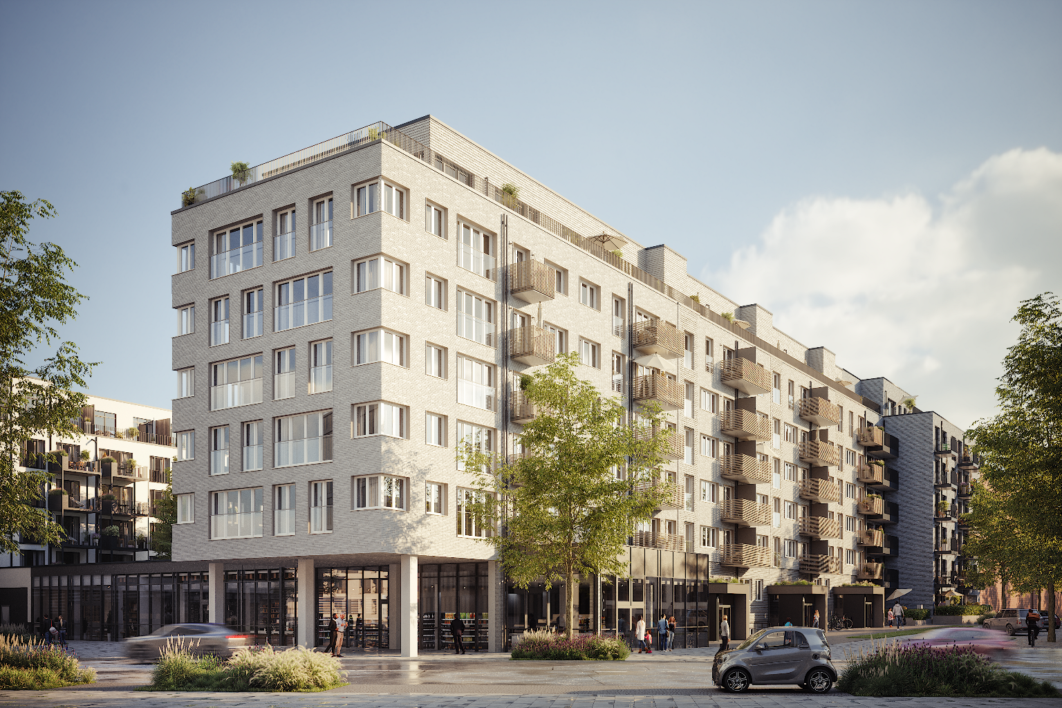 Exterior view of a modern, light-gray brick apartment building with balconies and large windows on a sunny day.