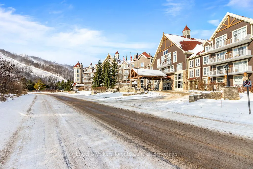 Winter view of a brown multi-story building with red roofs and snow-covered ground.