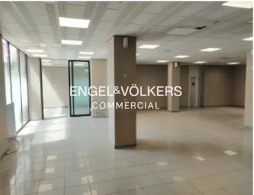 Empty commercial space with tile floors, large windows, and recessed lighting. Engel & Völkers Commercial logo is visible.