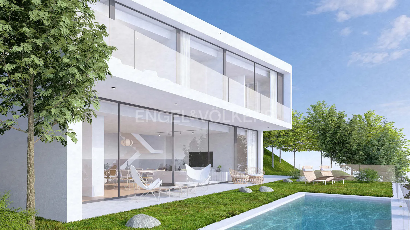 Modern white house with floor-to-ceiling windows, a pool, and green lawn. Engel & Völkers logo visible on the glass.