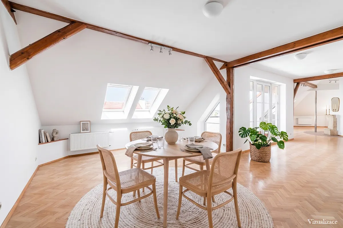 Bright attic apartment with exposed beams, a round dining table set for four, and a large Monstera plant.