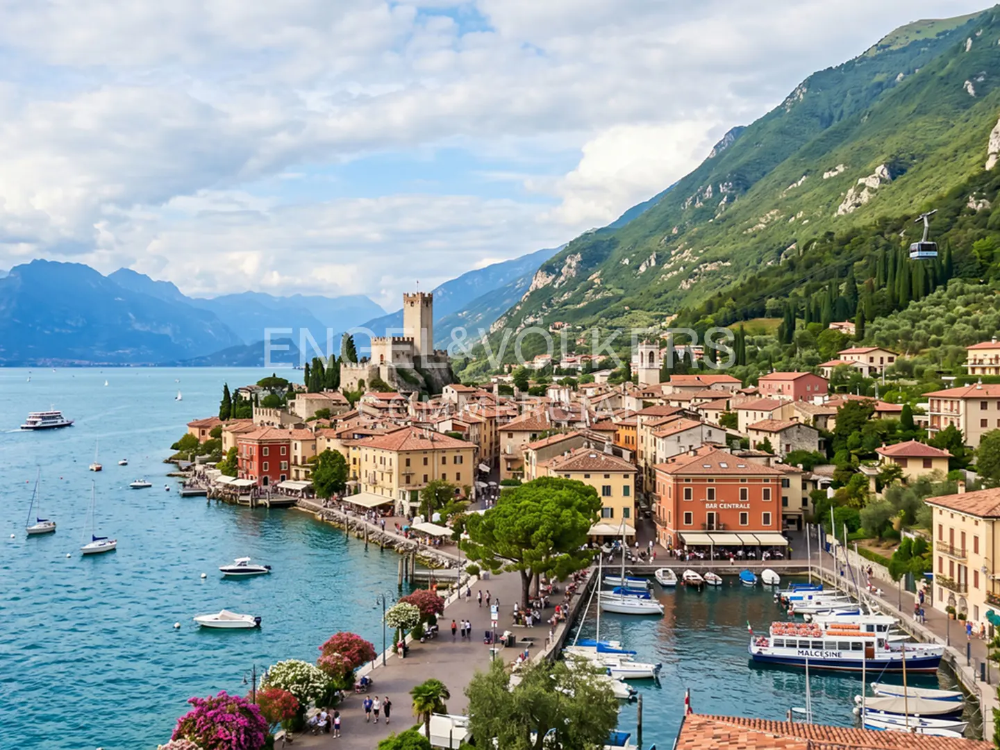 Scenic view of Malcesine, Italy, featuring a castle, harbor with boats, and mountains under a partly cloudy sky.