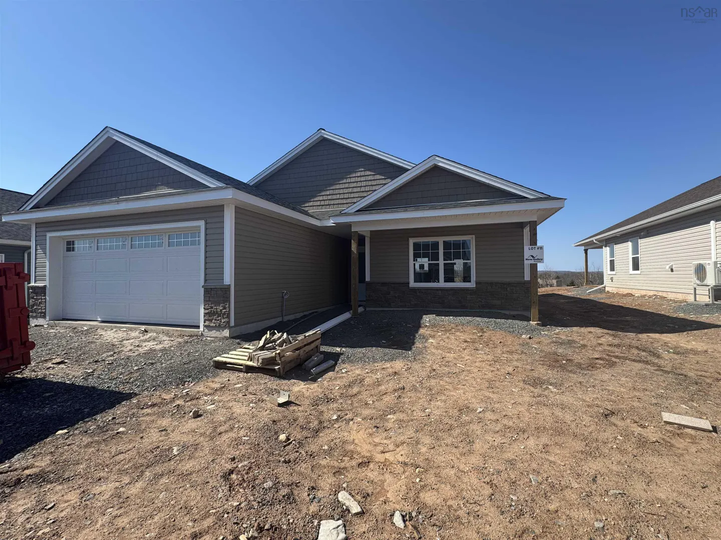 New construction home with brown siding, gray shingle roof, and white garage door on a sunny day.