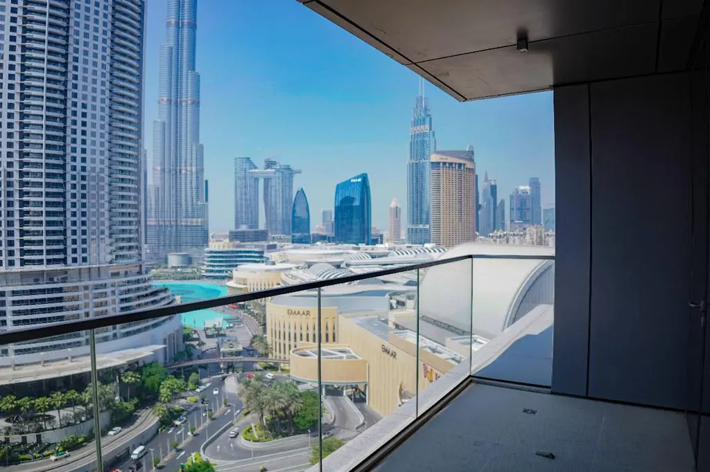 View from a modern balcony overlooking the Dubai skyline, featuring the Burj Khalifa and surrounding city architecture.
