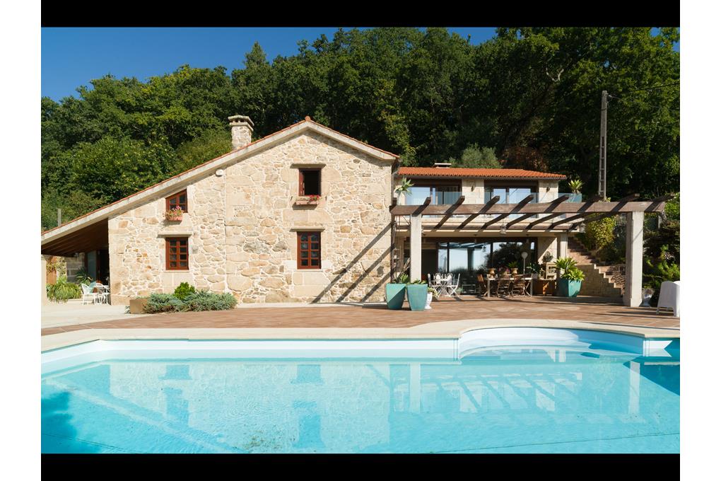 E&V sells a luxury five-bedroom villa in Brión, with grounds and a saltwater pool