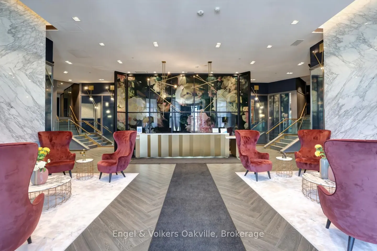 Hotel lobby with red velvet chairs, marble walls, and a floral-patterned reception desk.