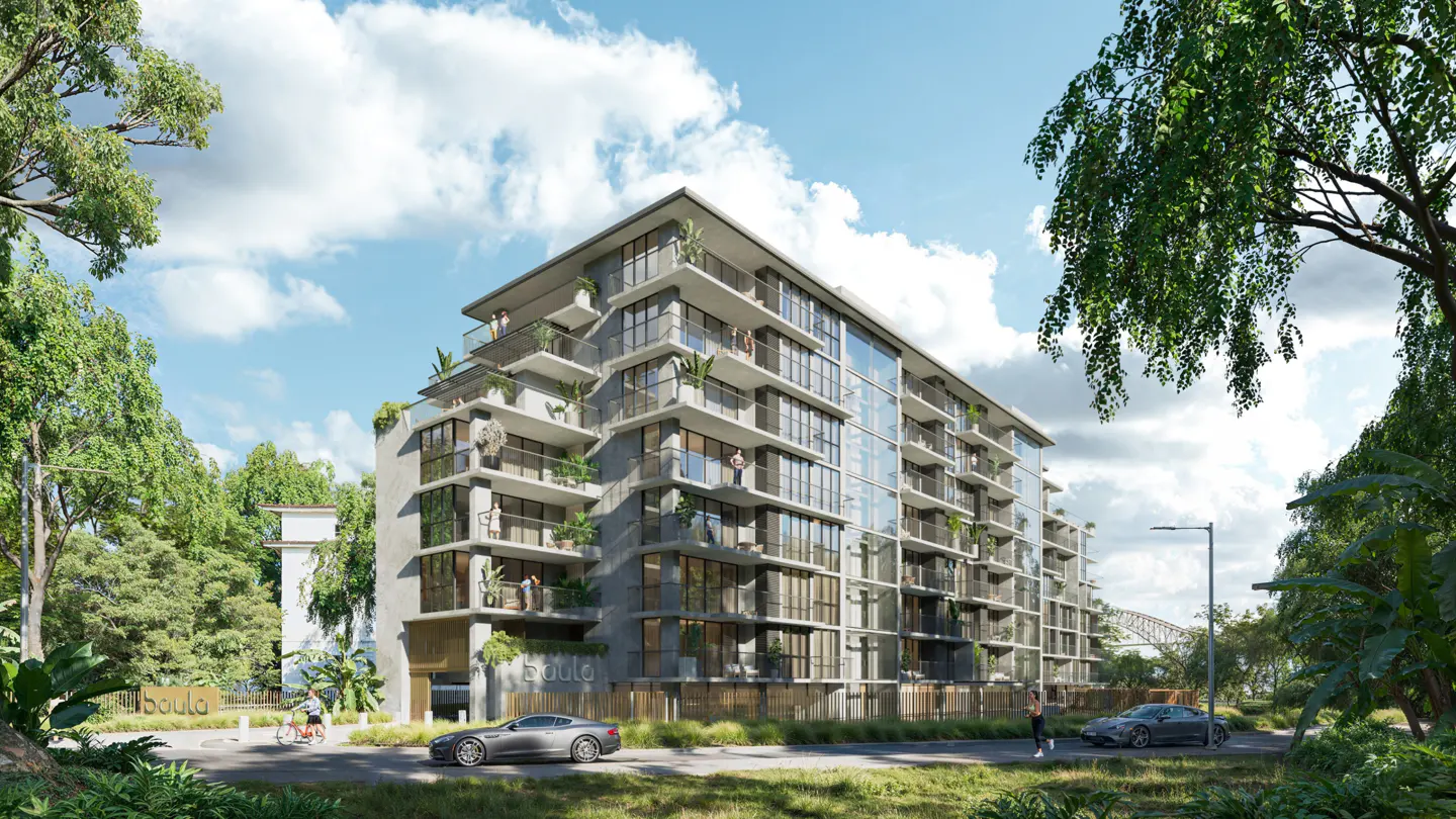 Modern gray apartment building with balconies and glass windows, surrounded by lush green trees and blue sky.