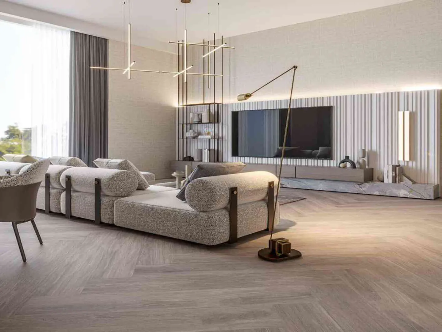 A modern living room with a large gray sectional sofa, a TV, and a floor lamp. The walls are light beige, and the floor is wood.