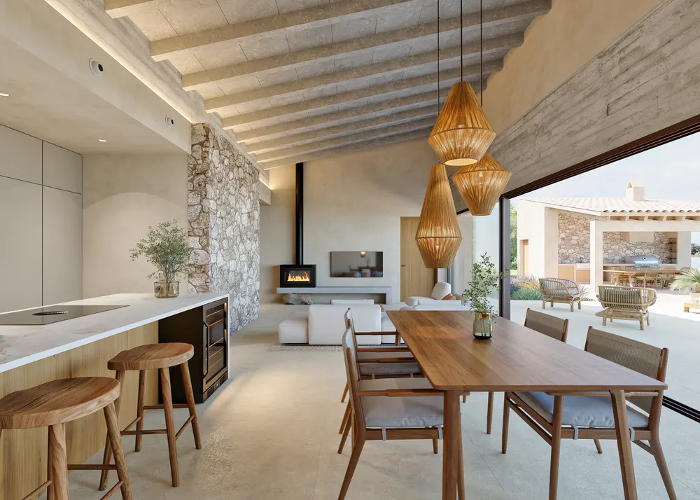 Open-concept kitchen and dining area with stone wall, wood table, and woven pendant lights. Patio with outdoor seating visible.