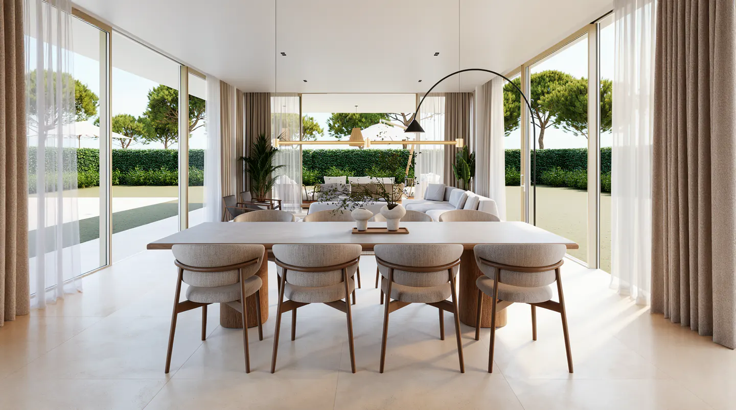 Bright, modern dining room with a long table, chairs, and open view to a green outdoor space. Neutral tones dominate the interior design.