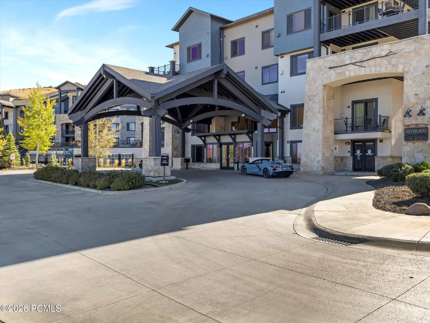 Exterior view of the Silverado Lodge, a multi-story building with a porte-cochère and a blue sports car parked nearby.