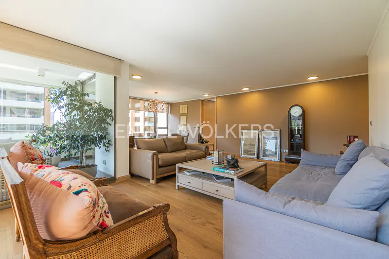 Living room with hardwood floors, a brown sofa, a blue sofa, a coffee table, and a grandfather clock.