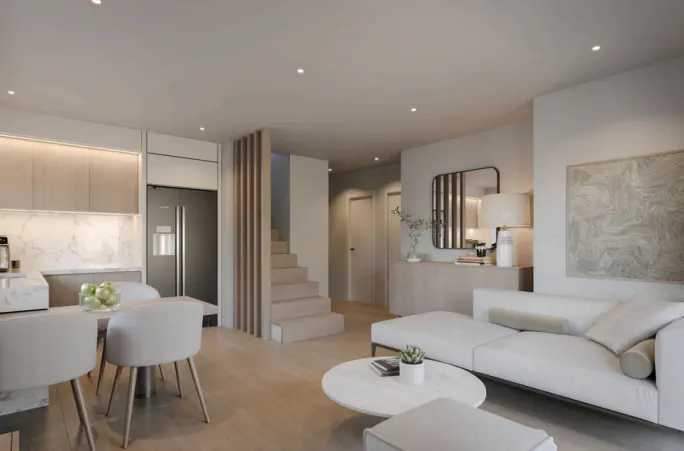 Open-concept living space with a kitchen, dining area, and living room in neutral tones. Stairs lead to an upper level.