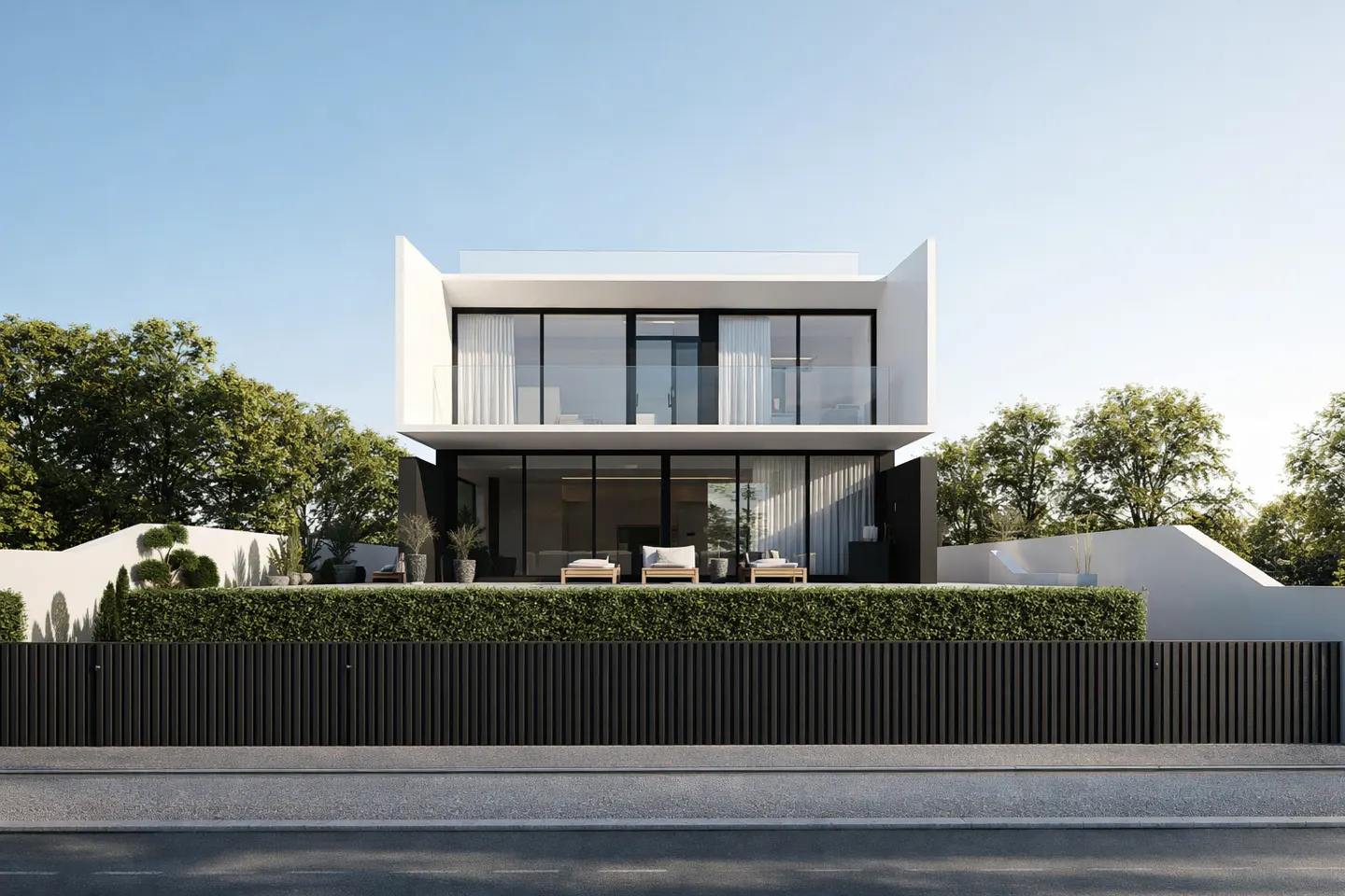 Modern two-story white house with black trim, large windows, and a black fence, set against a blue sky and green trees.
