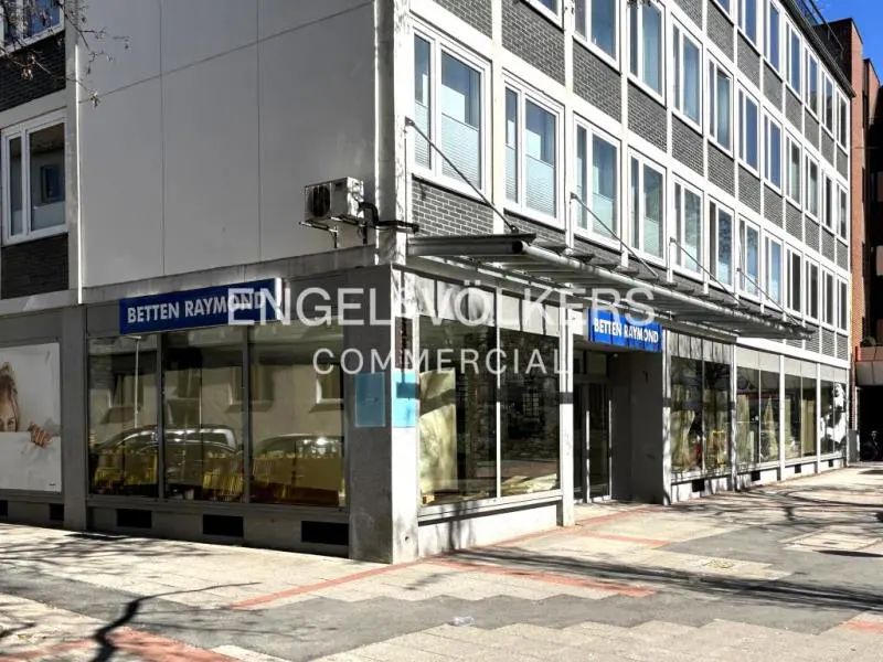 Exterior view of a multi-story building with "Engel & Völkers Commercial" signage above a storefront with large windows.