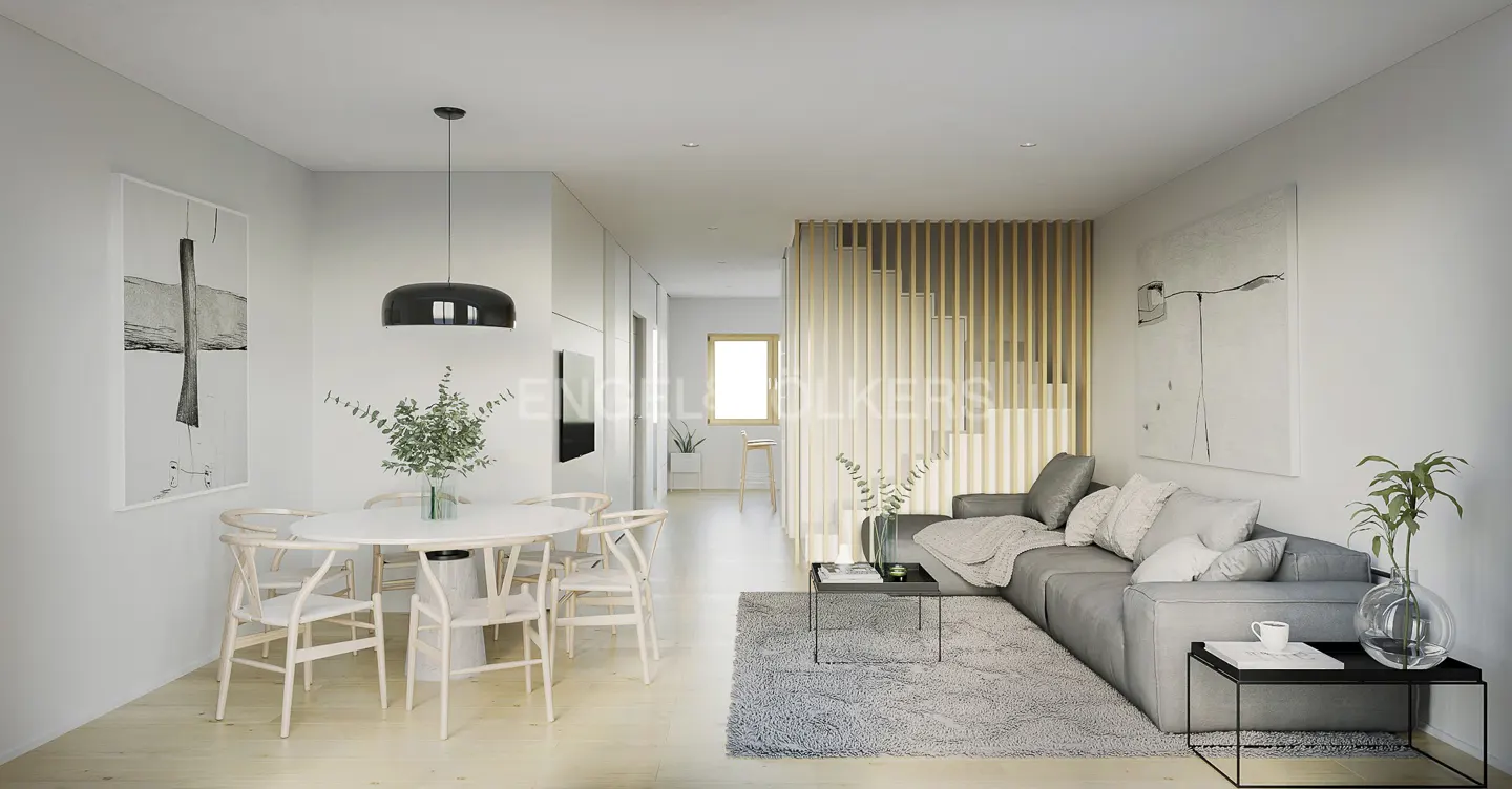 Bright, modern living space with a gray sofa, round white table, and wooden staircase. Artwork adorns the white walls.