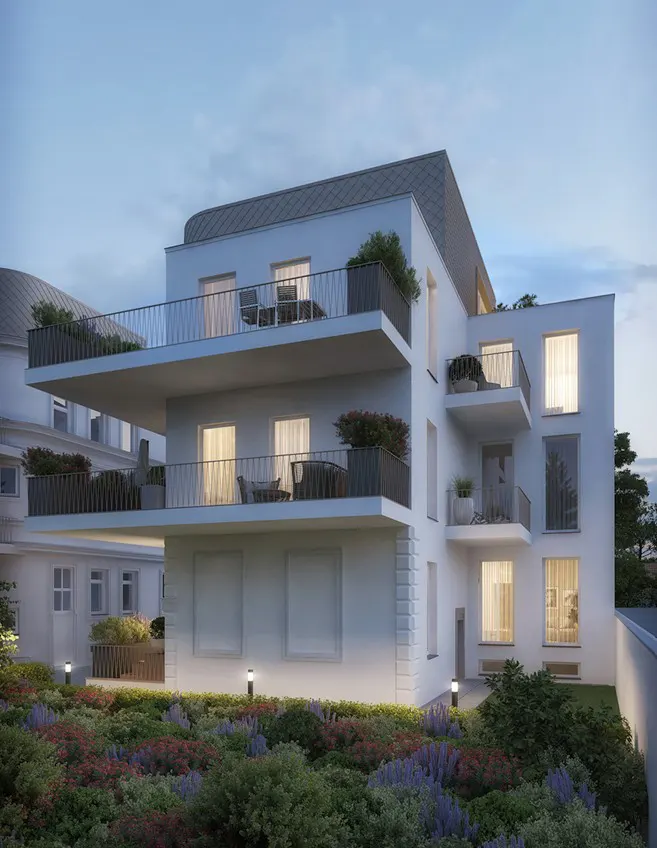 Modern white apartment building at dusk with spacious balconies, large windows, and a landscaped garden in the foreground.