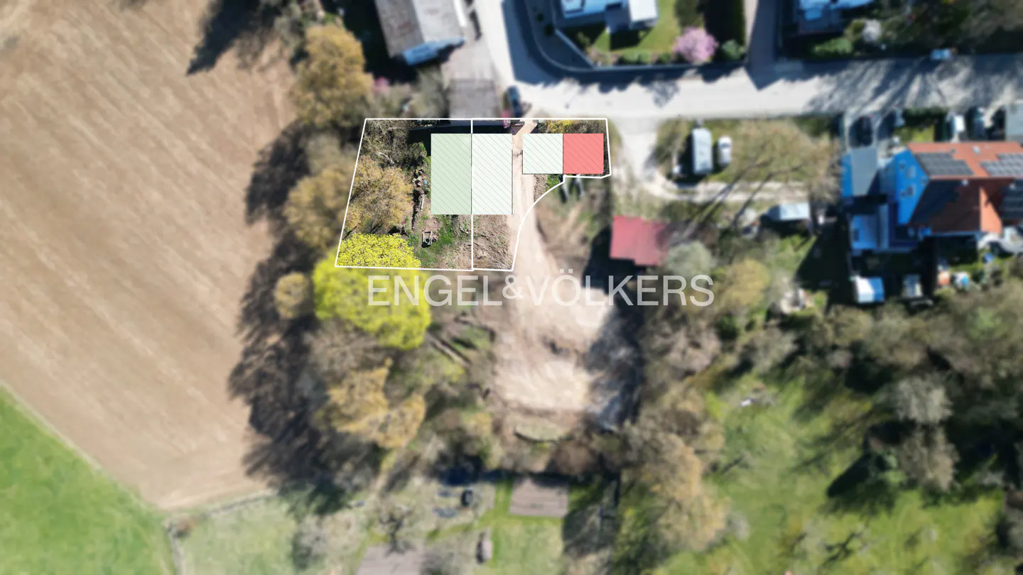 Aerial view of a property outlined in white, with green and red shaded areas, and the Engel & Völkers logo.