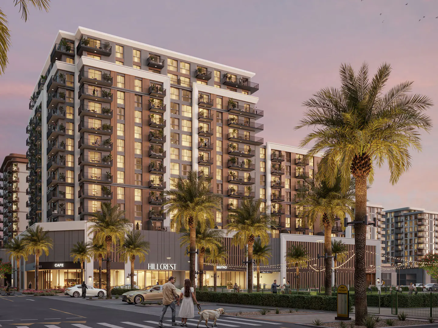 Modern high-rise apartment building with balconies, palm trees, and street-level shops. A couple walks a dog across a crosswalk.