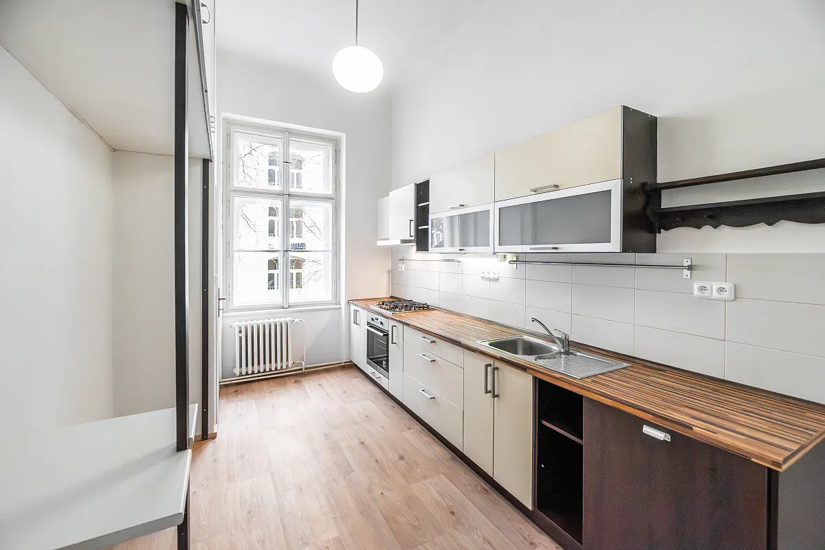 Bright kitchen with white cabinets, wood countertops, and stainless steel sink. A window provides natural light.