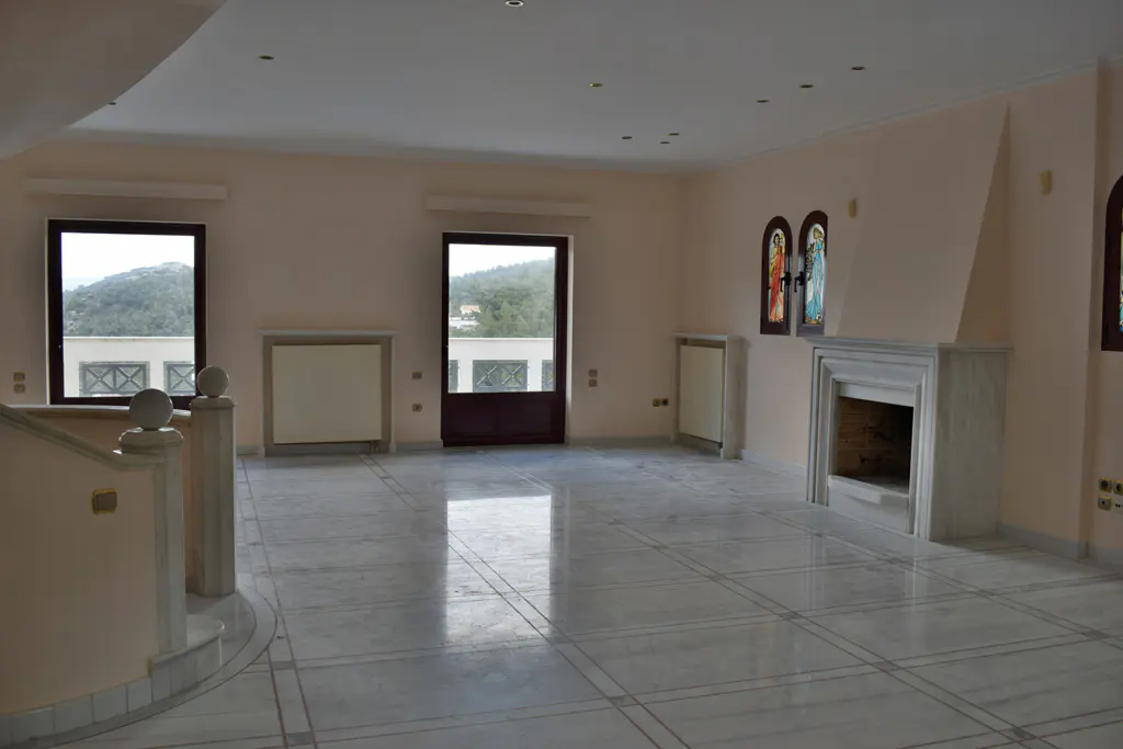 A spacious room with marble floors, a fireplace, and stained glass windows.