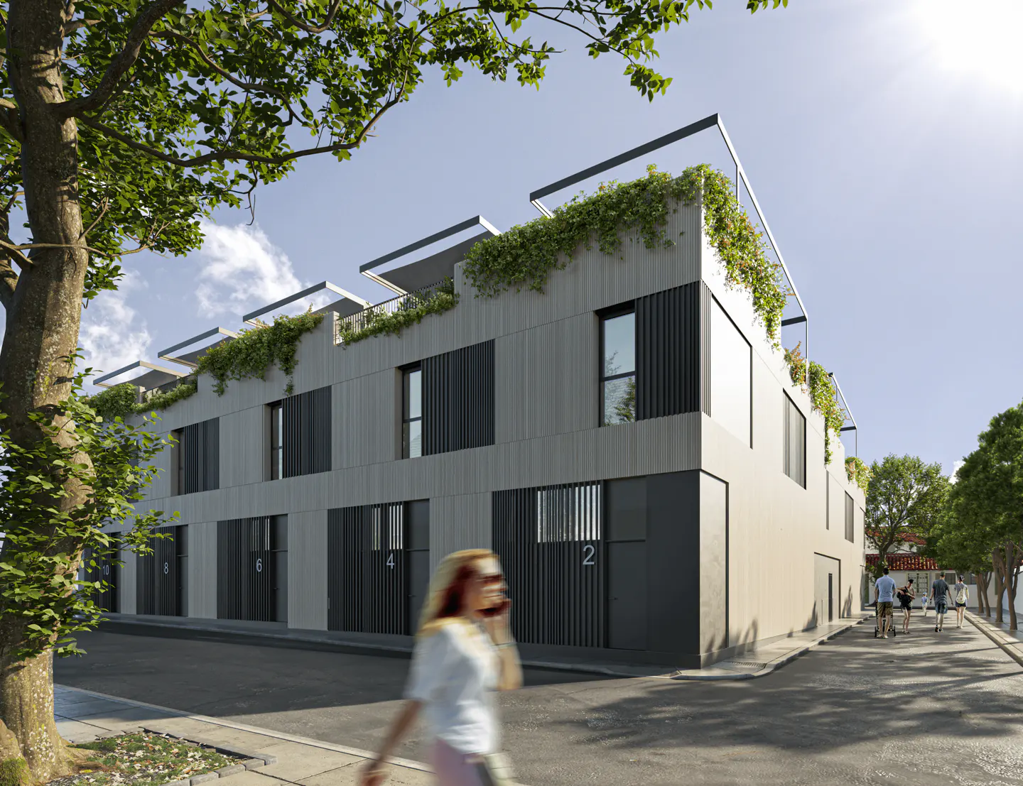 Modern multi-story apartment building with grey paneling, rooftop greenery, and numbered entrances on a sunny street.