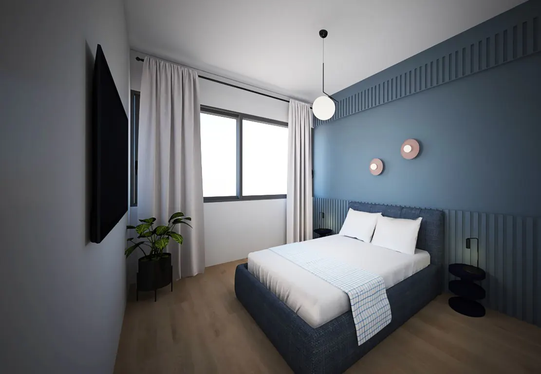 Bedroom with blue accent wall, white bedding, and a blue bed frame. A black TV is mounted on the wall, and a plant sits near the window.