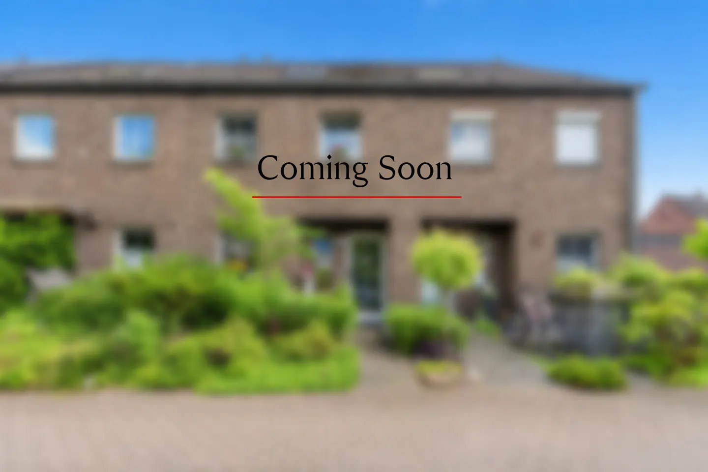 Blurred image of a brick townhouse with "Coming Soon" text overlayed in black with a red underline.