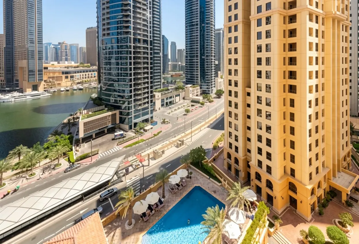 High-angle view of a Dubai cityscape with a blue swimming pool, palm trees, modern skyscrapers, and a canal.