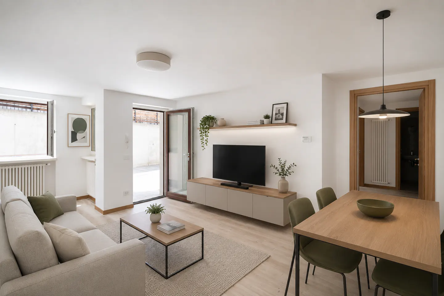 Bright living room with a beige sofa, wood table, and TV. Open doors lead to a patio. Modern, minimalist design.