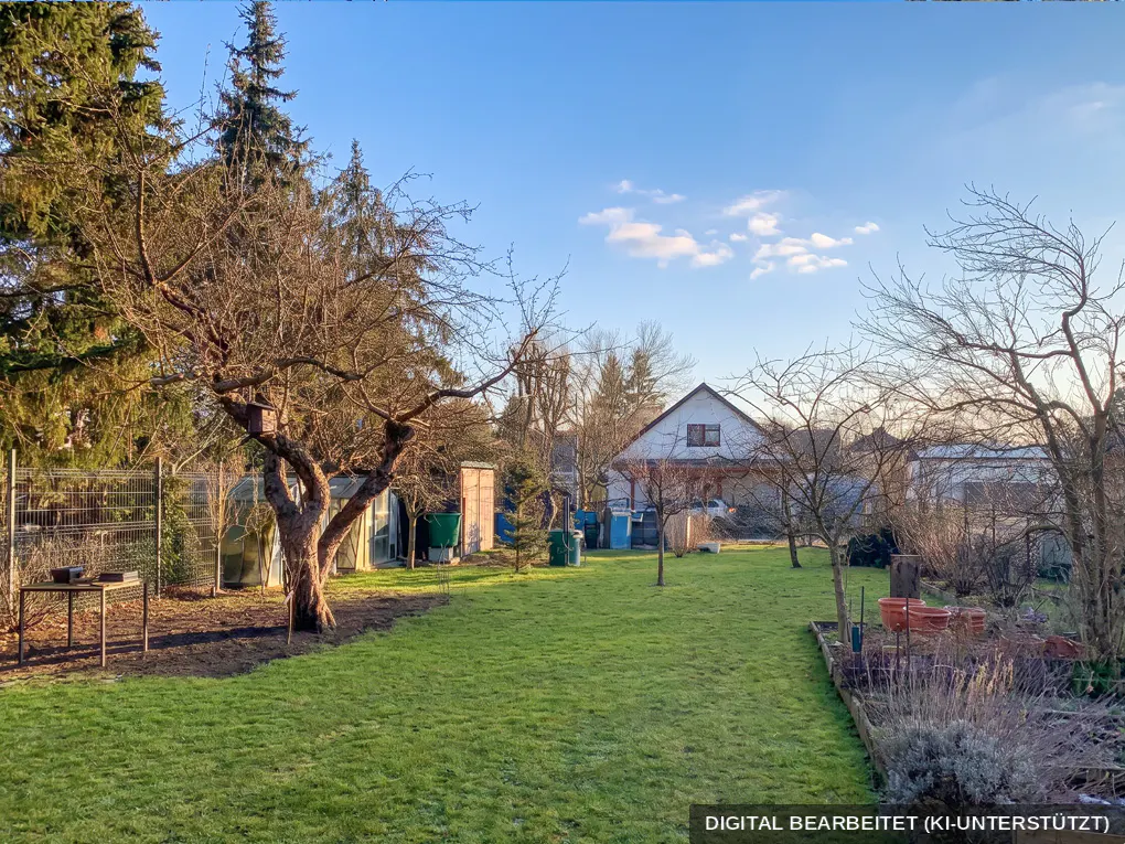 A wide shot of a green backyard with a house in the background on a sunny day.