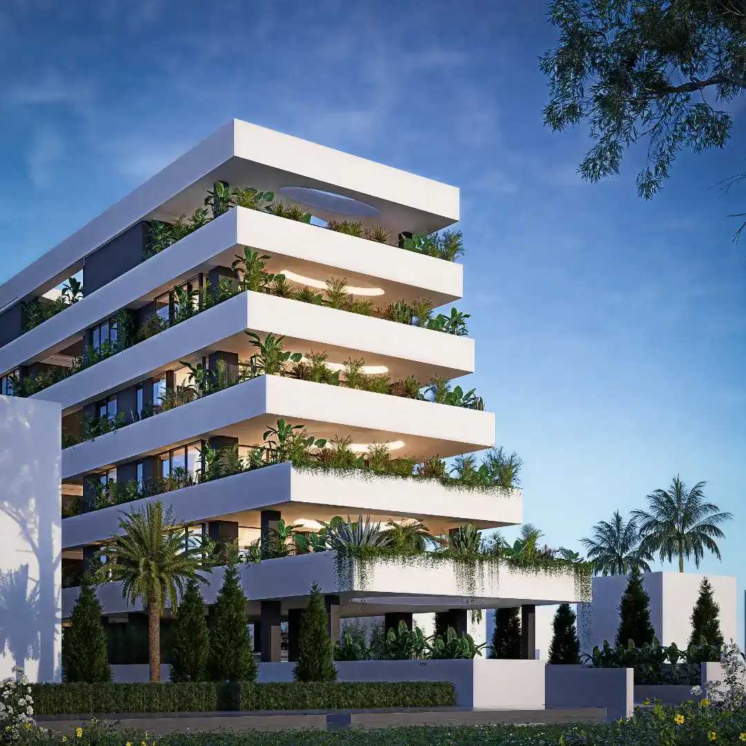 Modern white apartment building with layered balconies filled with lush green plants against a blue sky.