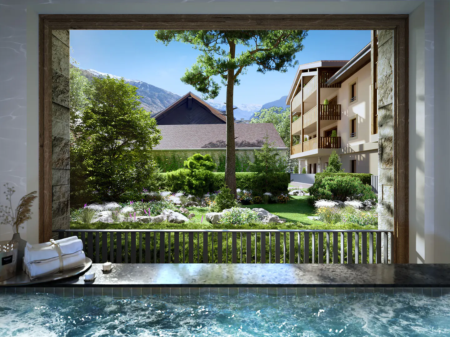 View from a blue-tiled hot tub, with stacked white towels, to a green garden, buildings, and mountains beyond.