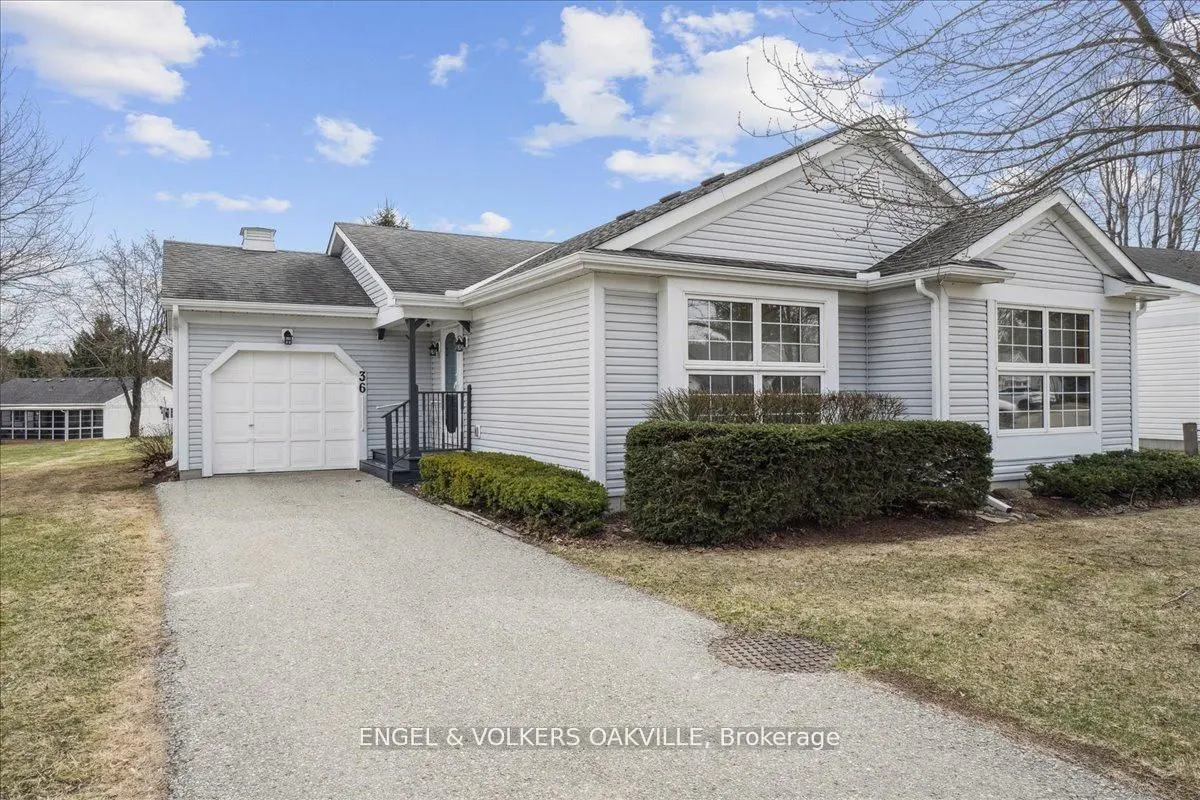 Exterior view of a one-story, light gray house with a white garage door and a gray roof on a sunny day.